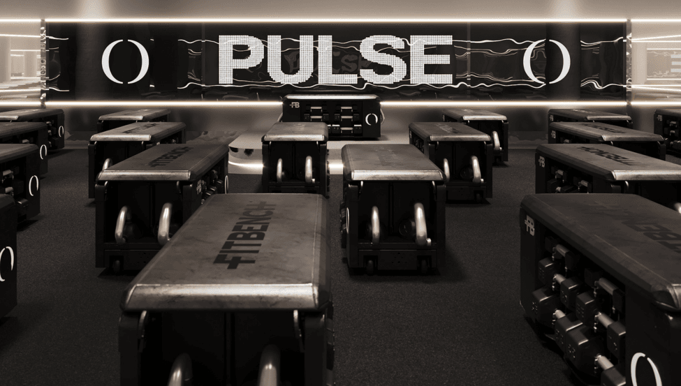 A group fitness studio with benches, dumbbells and a big screen