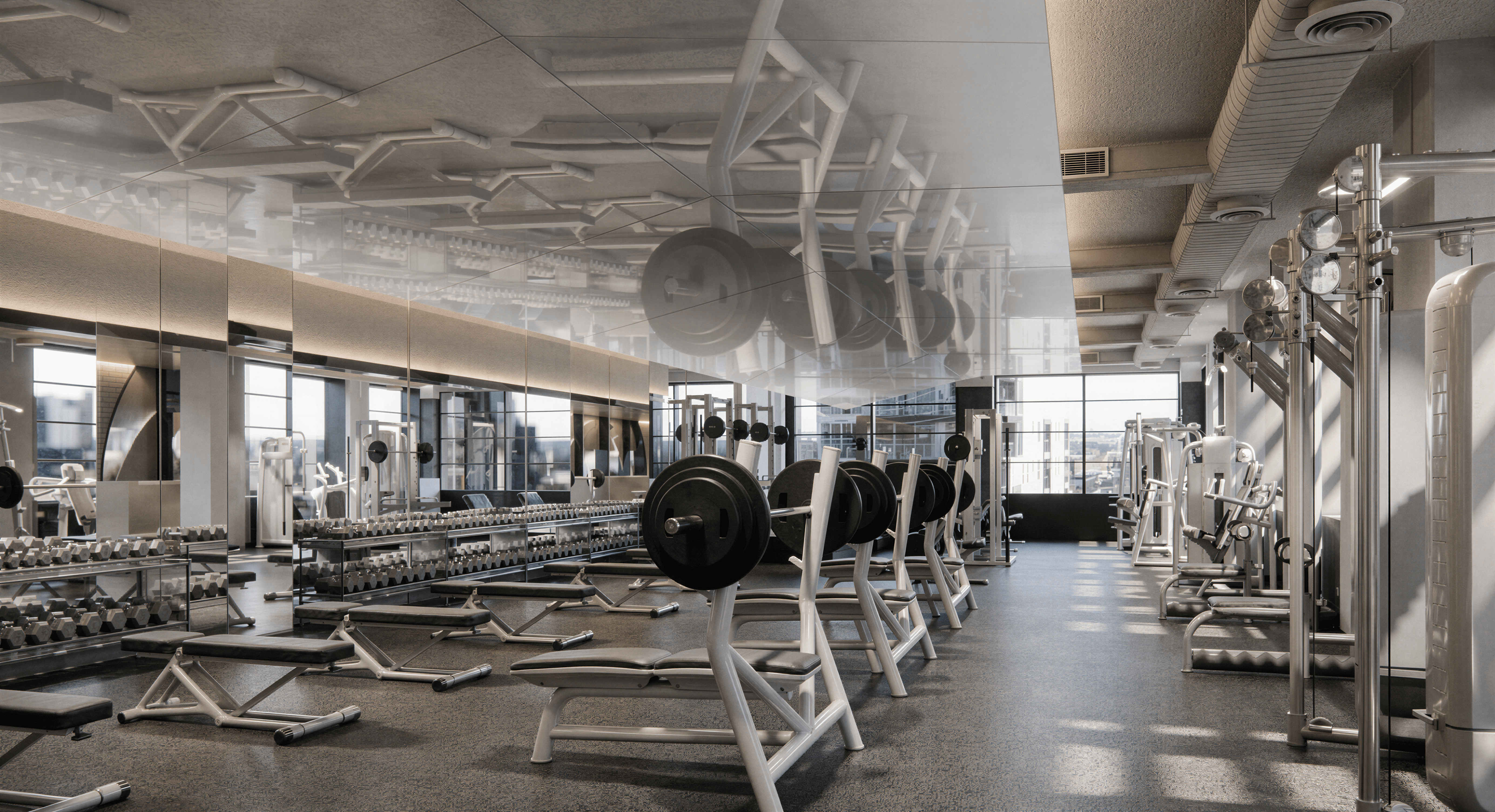A gym floor with benches, barbells, dumbbells and cable machines